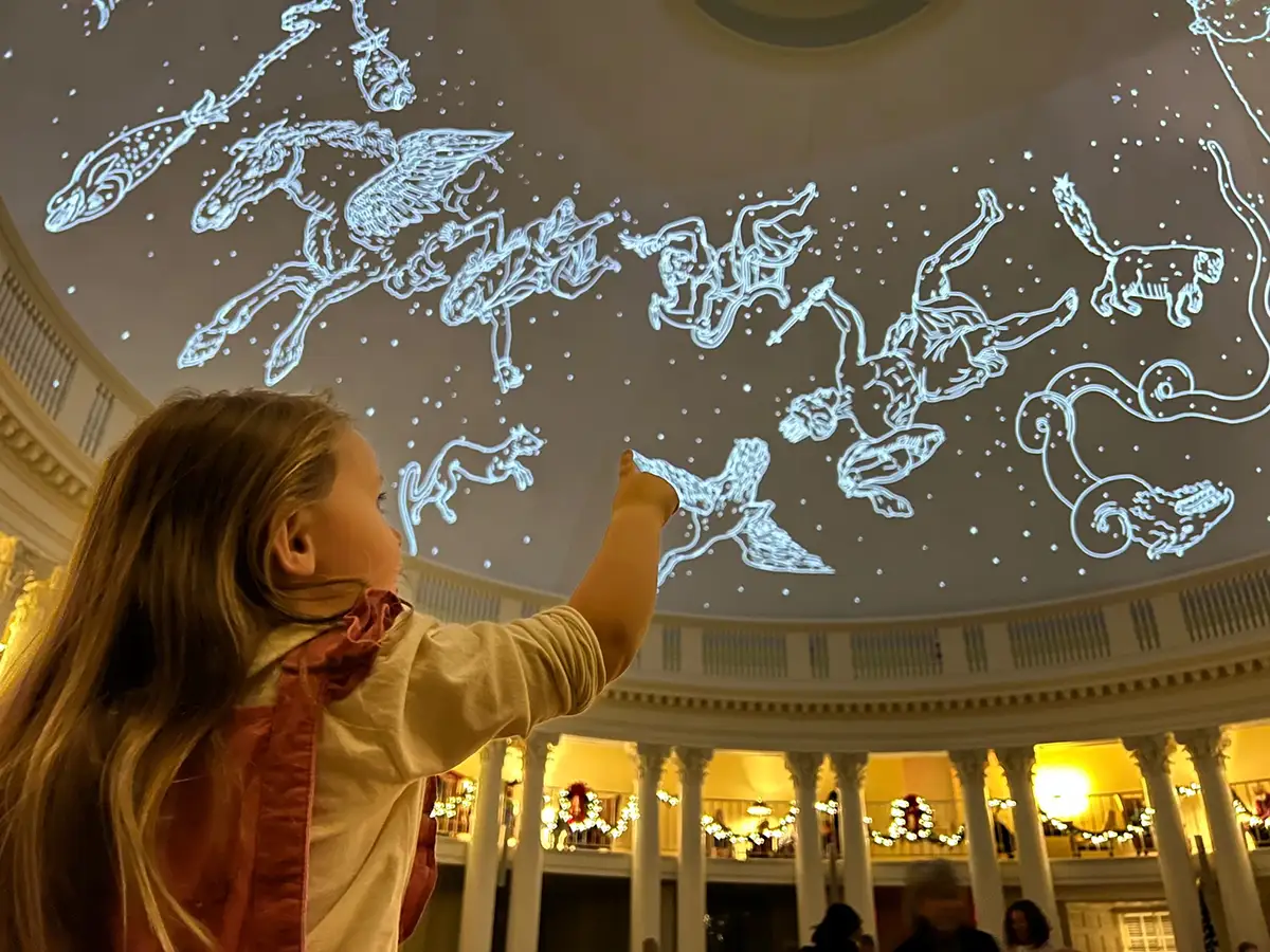 Child pointing to the constellations displayed on the dome of the Rotunda
